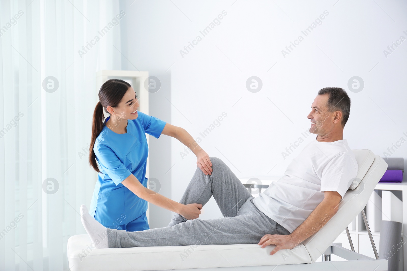 Photo of Doctor working with patient in hospital. Rehabilitation physiotherapy