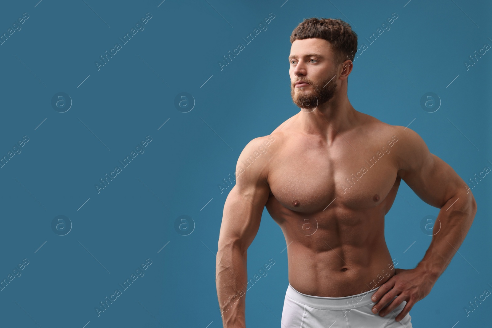 Photo of Handsome muscular man on light blue background, space for text. Sexy body