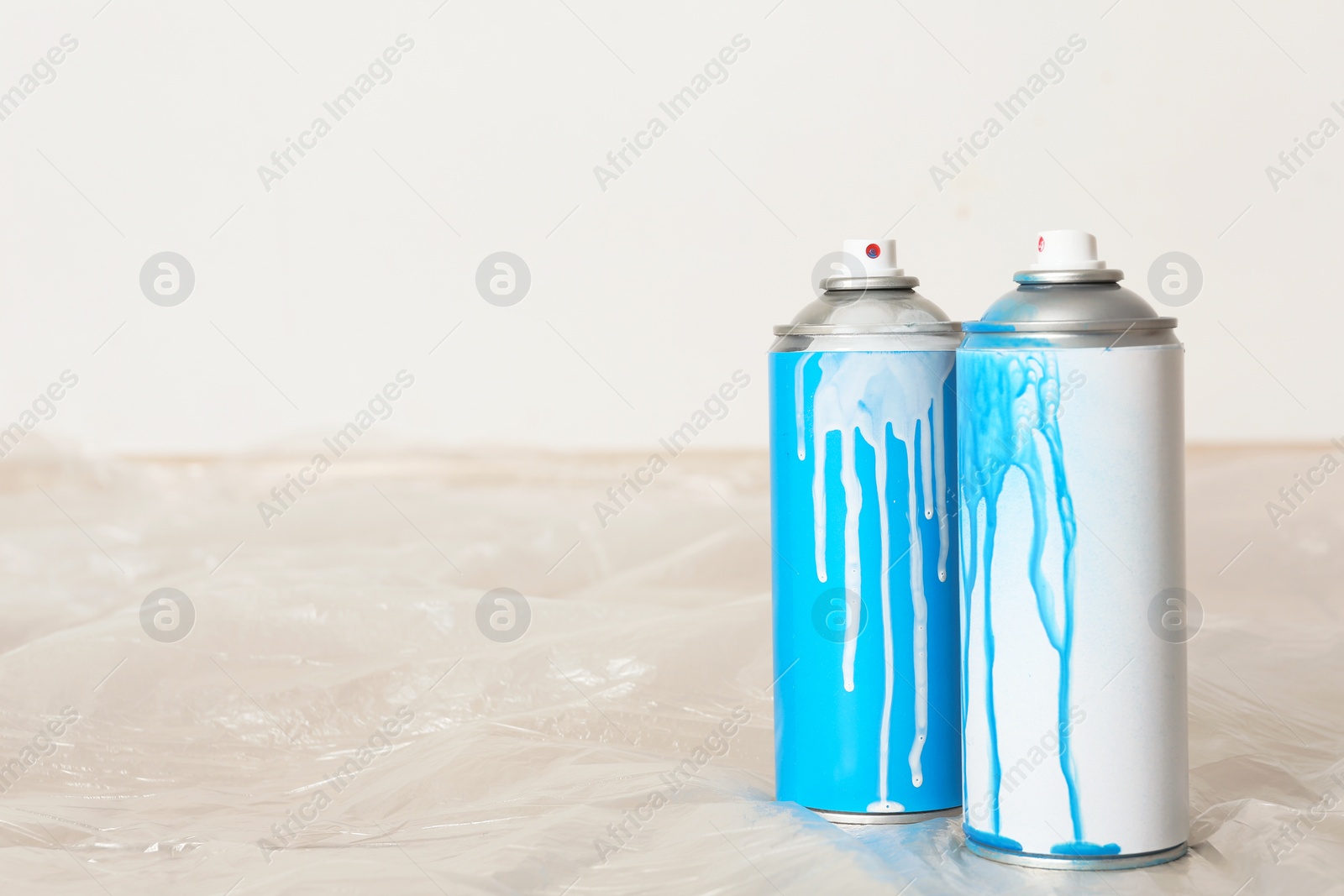 Photo of Used cans of spray paint indoors. Space for text