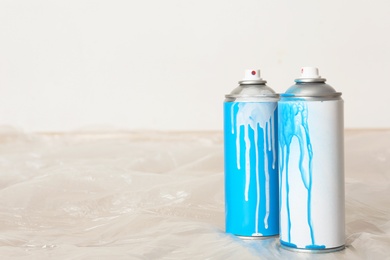 Used cans of spray paint indoors. Space for text