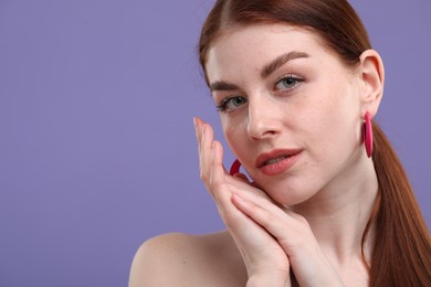 Photo of Portrait of beautiful woman with freckles on purple background. Space for text