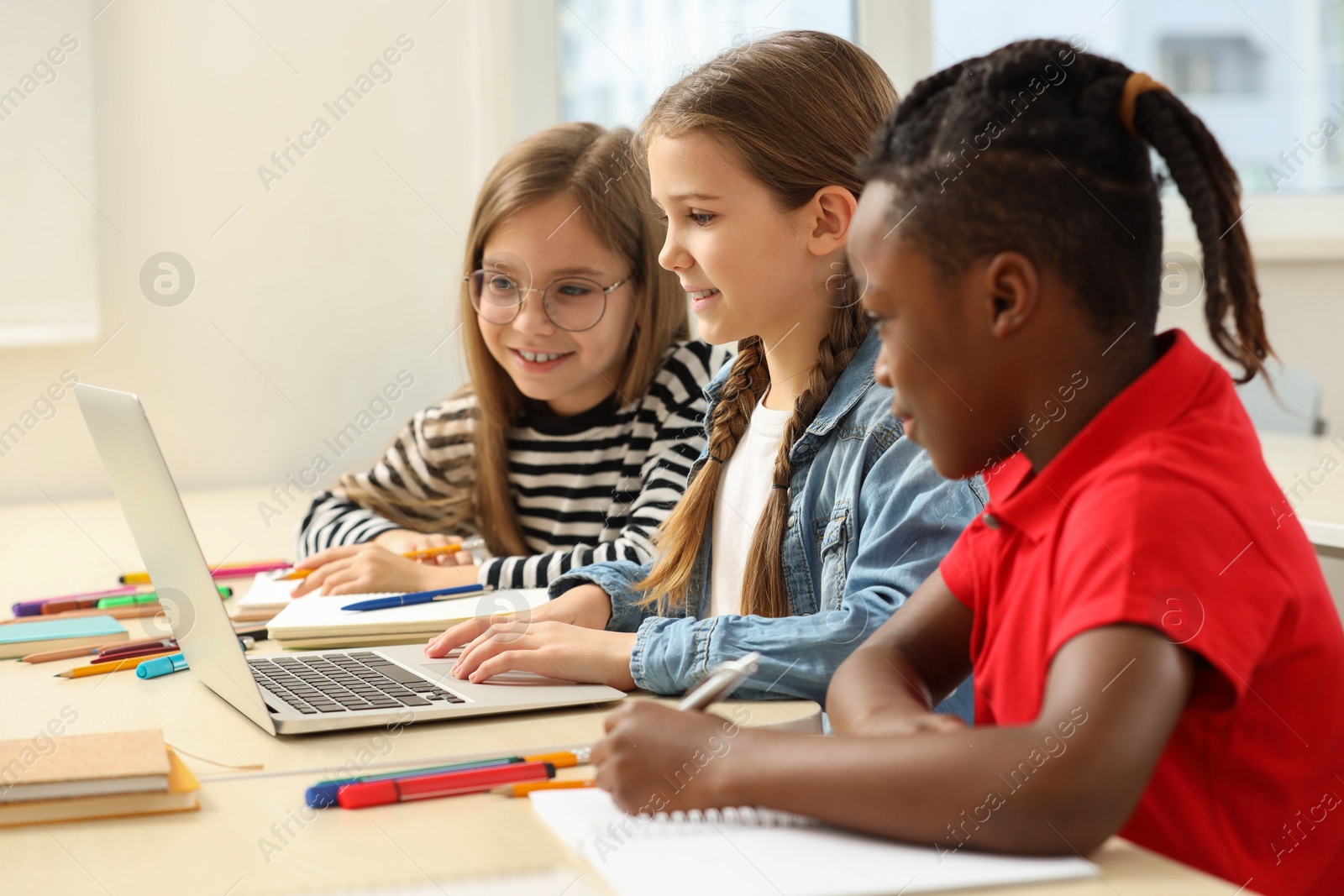 Photo of Cute children studying in classroom at school