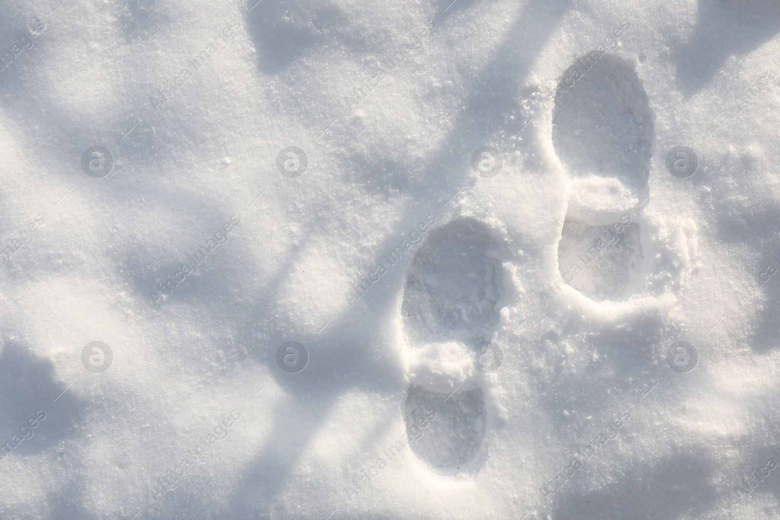 Photo of Bootprints on snow outdoors, top view. Winter season