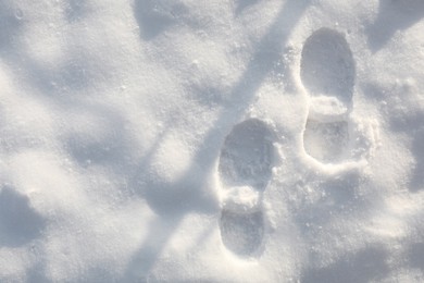 Photo of Bootprints on snow outdoors, top view. Winter season