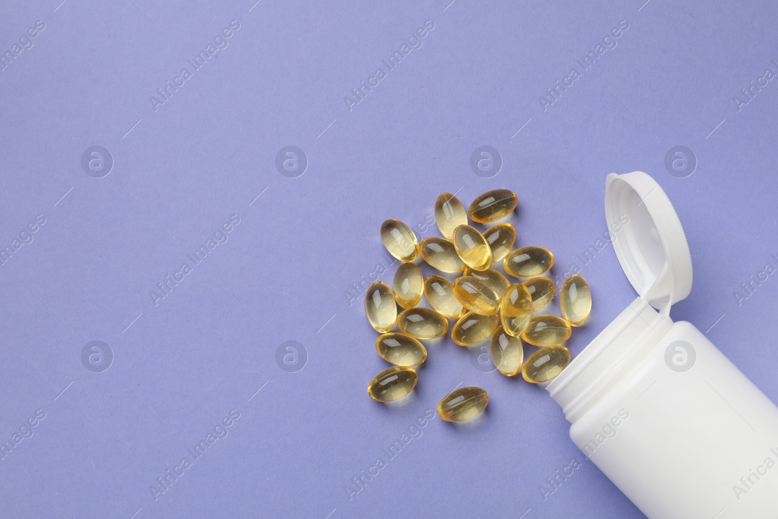 Photo of White bottle and vitamin capsules on violet background, top view. Space for text