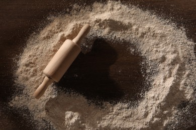 Photo of Frame of flour and rolling pin on wooden table, top view. Space for text