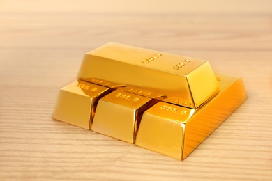 Stacked shiny gold bars on wooden table