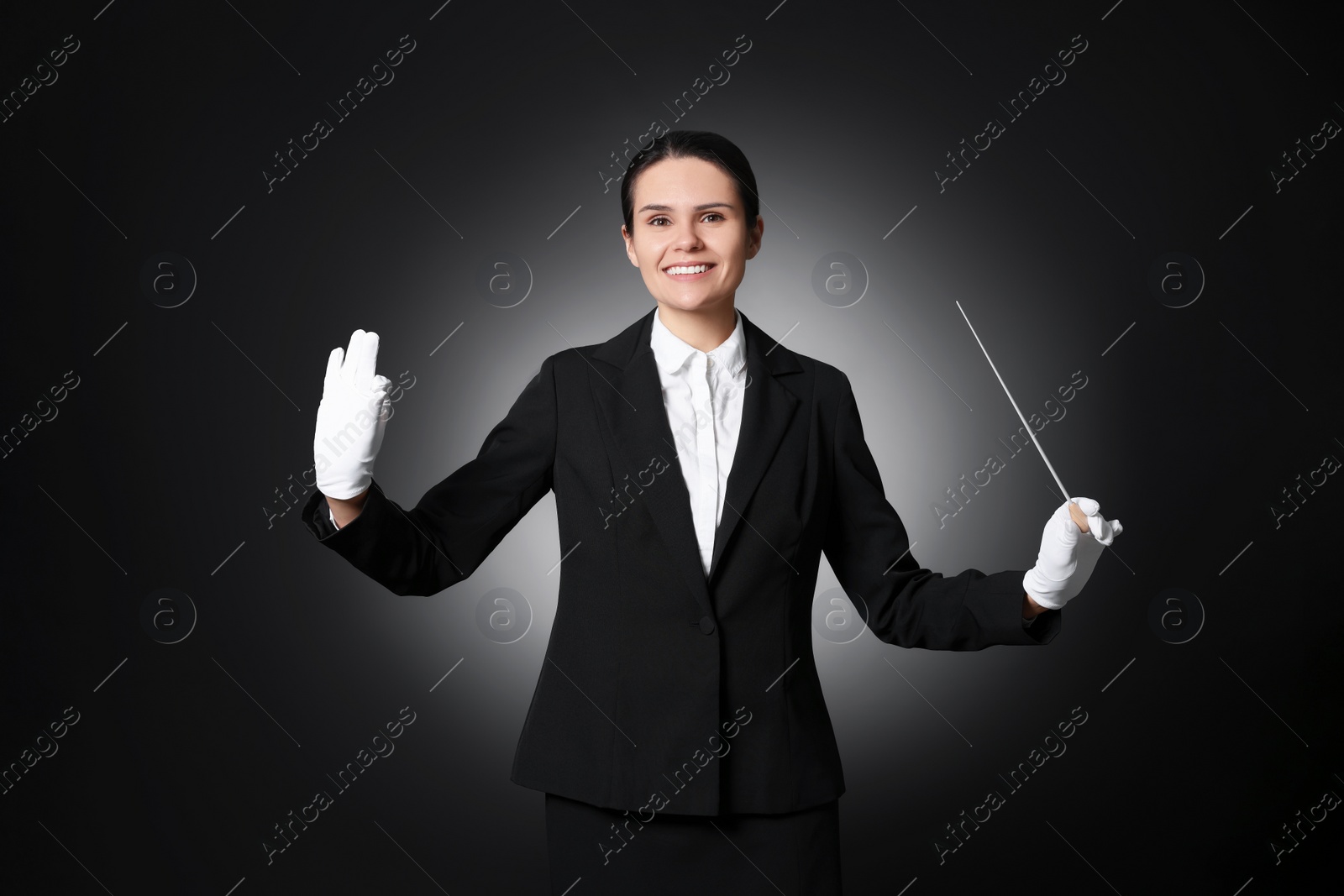 Photo of Happy professional conductor with baton on black background