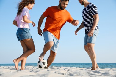 Group of friends playing football on beach