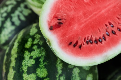 Photo of Delicious whole and cut watermelons as background, closeup