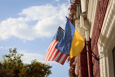 Photo of Flags of Ukraine and USA on building facade