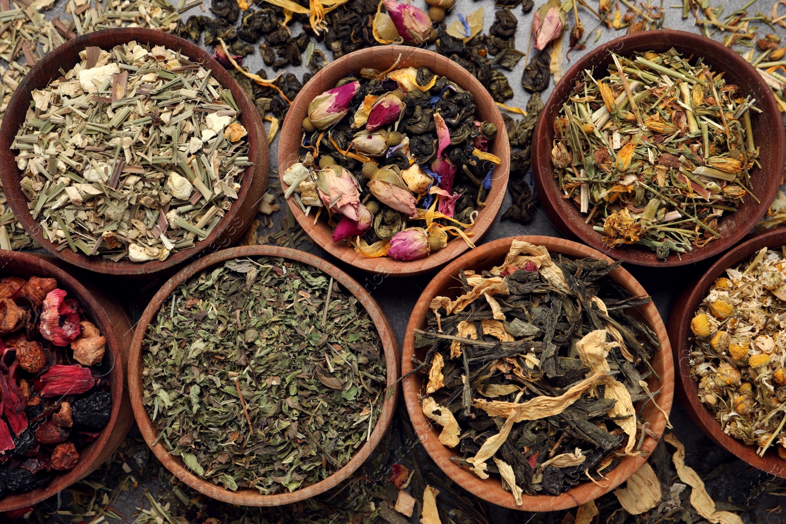 Photo of Flat lay composition with different dry teas on grey table