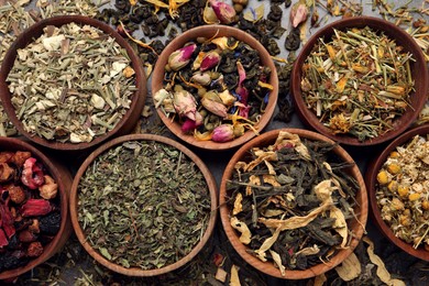 Photo of Flat lay composition with different dry teas on grey table