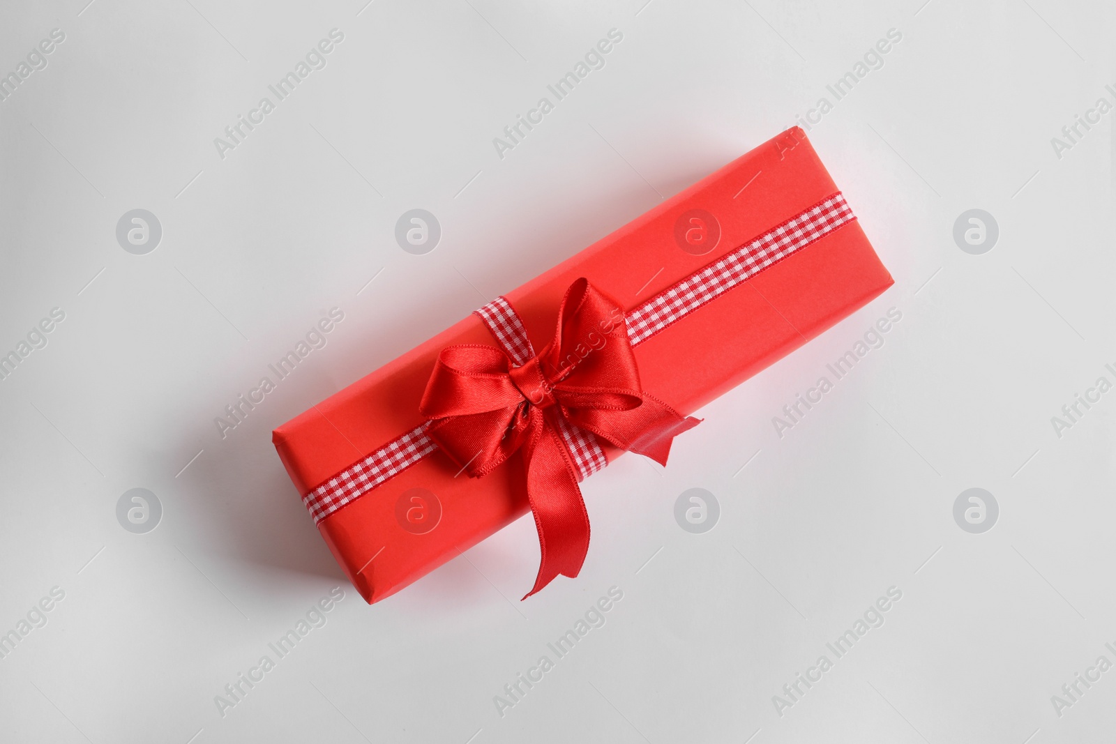 Photo of Beautifully wrapped gift box on white background, top view