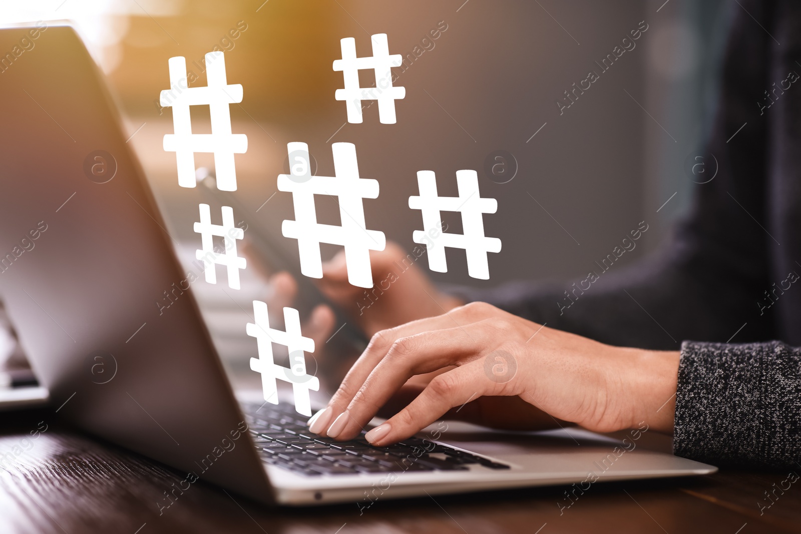 Image of Woman using modern laptop at table, closeup. Hashtag symbols over device