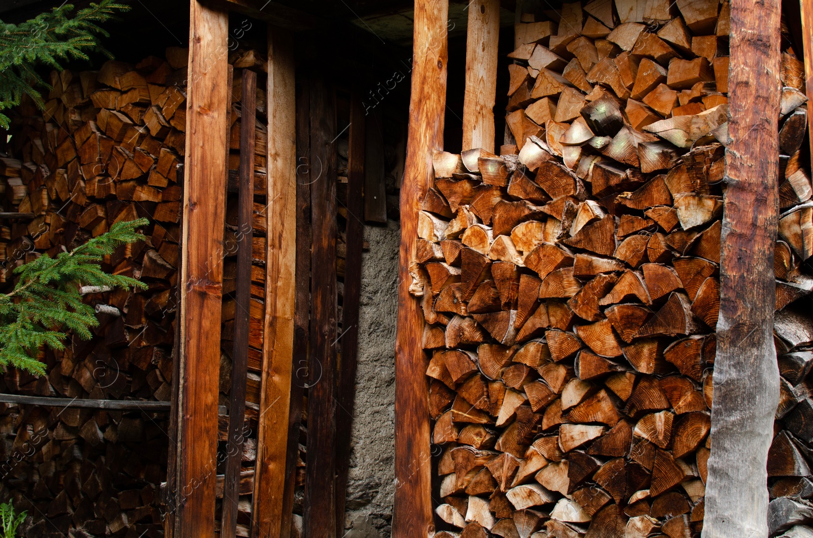 Photo of Closeup view of stacked cut firewood in outdoor warehouse
