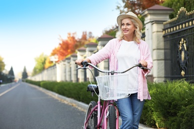 Photo of Mature woman with bicycle outdoors. Active lifestyle