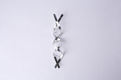 Photo of DNA molecular chain made of metal on white background, top view