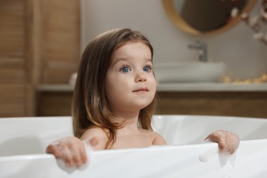 Photo of Cute little girl in bathtub at home. Hair washing