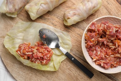 Photo of Preparing stuffed cabbage rolls on table, flat lay