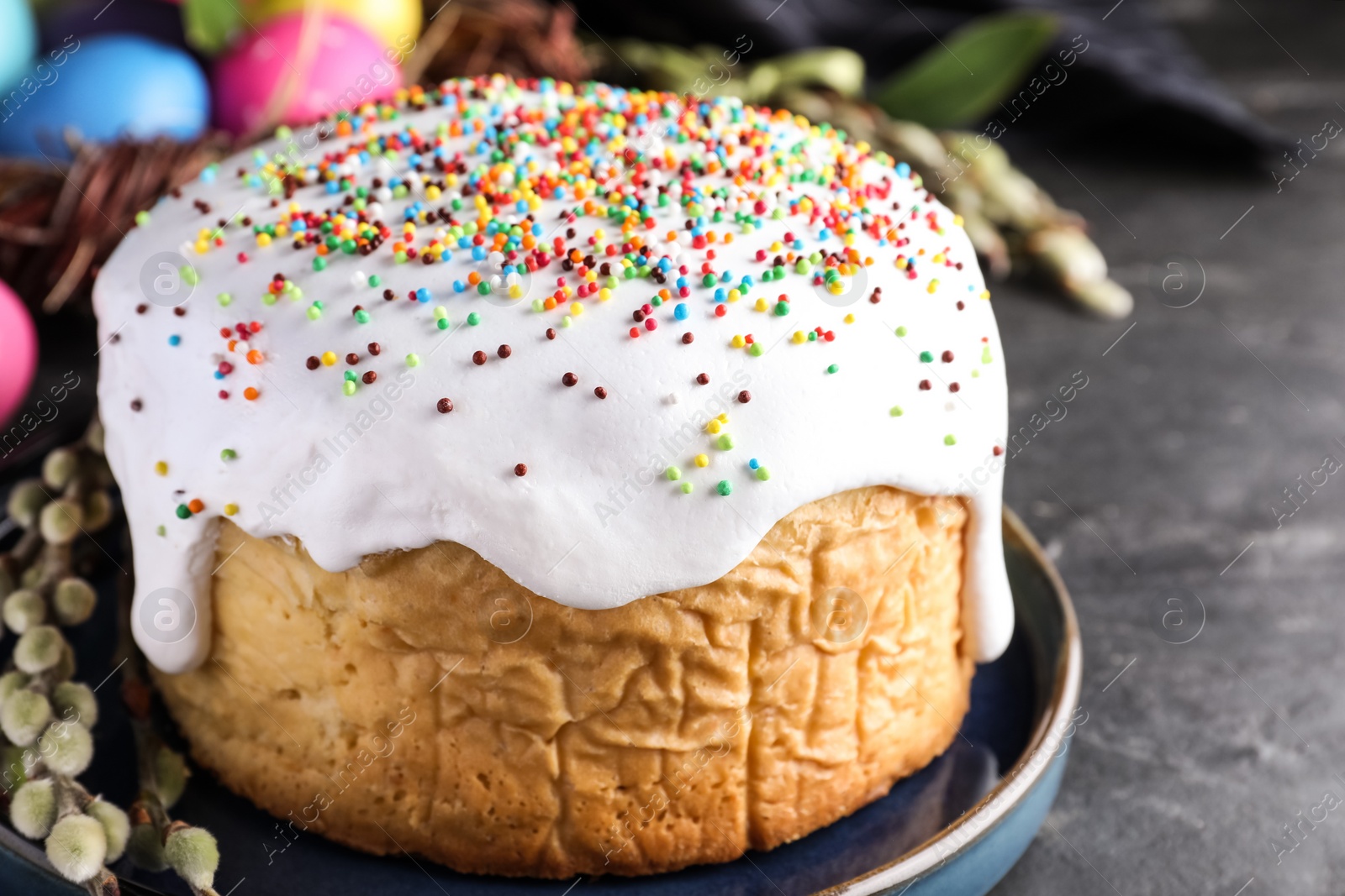 Photo of Traditional Easter cake and painted eggs on black table, closeup