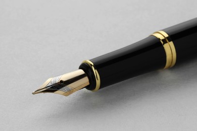 Photo of Stylish fountain pen on light grey table, closeup