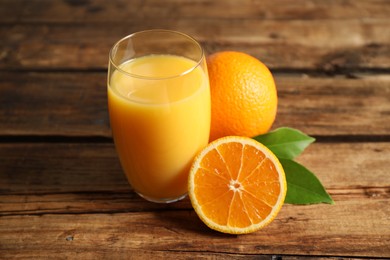 Glass of orange juice and fresh fruits on wooden table