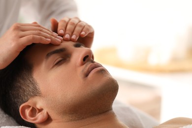 Photo of Man receiving facial massage in beauty salon, closeup