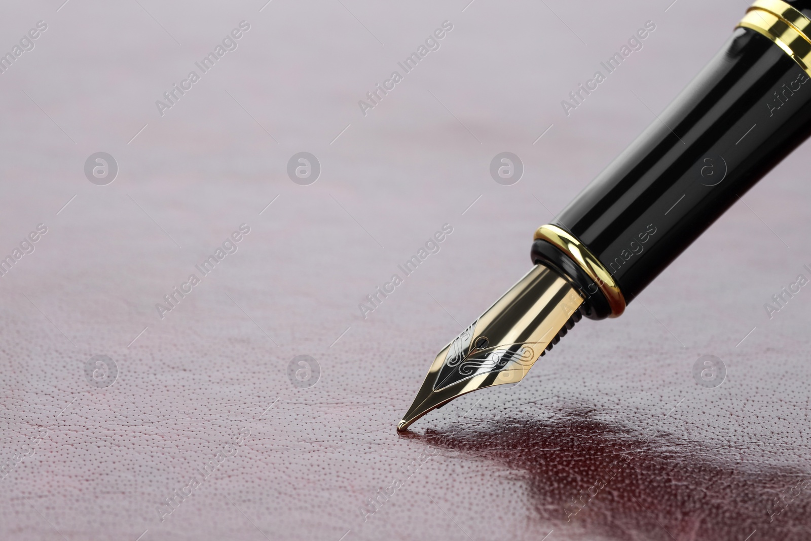 Photo of Stylish fountain pen on leather surface, closeup. Space for text