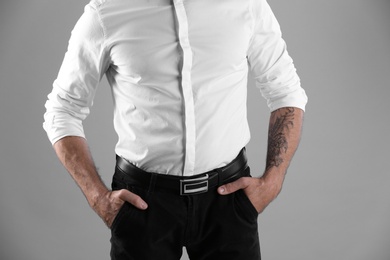 Photo of Tattooed man on grey background, closeup view