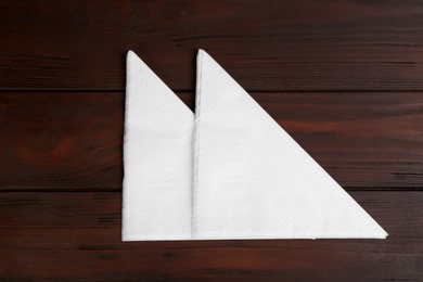 Photo of Clean napkins on wooden table, flat lay