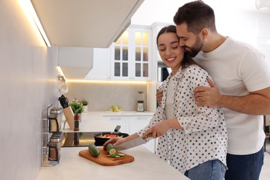 Photo of Happy lovely couple cooking together in kitchen