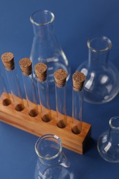 Photo of Different laboratory glassware on blue background, above view