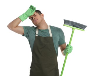 Tired man with green broom on white background