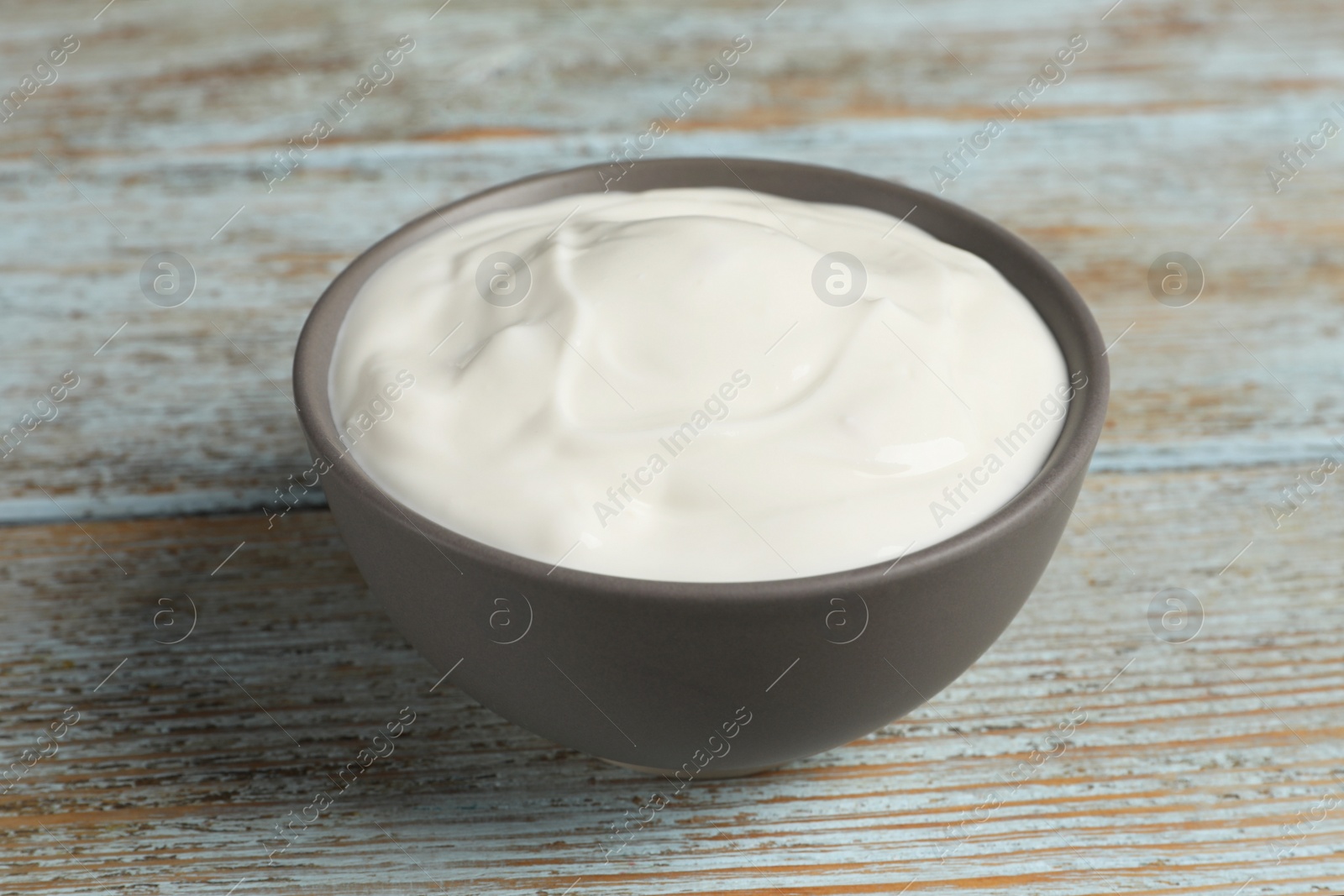 Photo of Ceramic bowl with delicious organic yogurt on wooden table, closeup