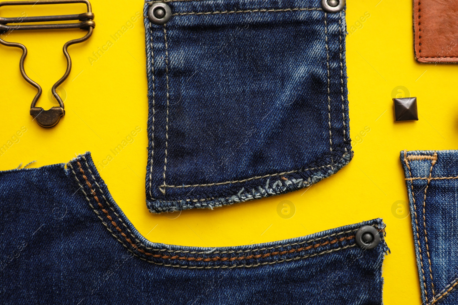 Photo of Flat lay composition with garment accessories and cutting details for jeans on yellow background