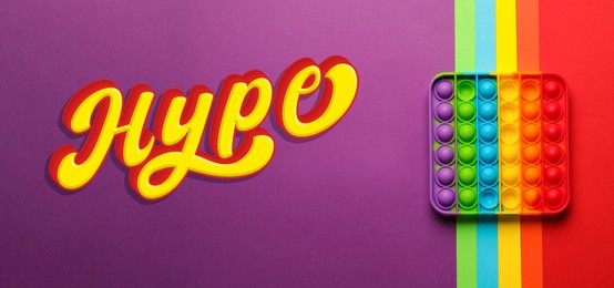 Image of Word Hype and rainbow pop it fidget toy on color background, top view. Banner design