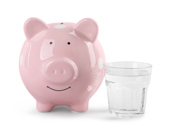 Photo of Water scarcity concept. Piggy bank and glass of drink isolated on white