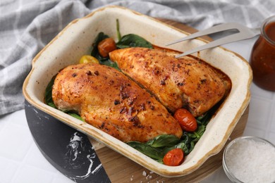 Photo of Baked marinated chicken fillets on white table, closeup