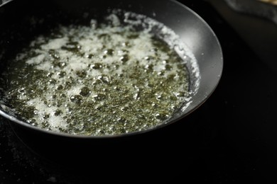 Photo of Melting butter in frying pan on black table, closeup