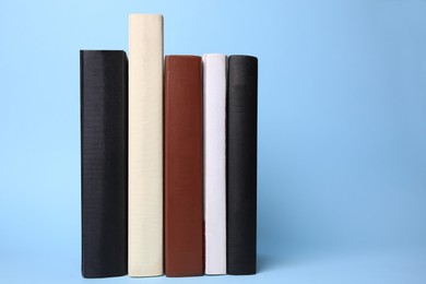 Photo of Collection of books on light blue background, space for text