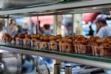 Photo of Bowls with fresh lokma on shelf at market. Traditional Turkish treat