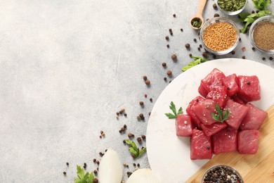 Photo of Raw beef meat and different ingredients for cooking delicious goulash on light grey table, flat lay. Space for text
