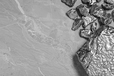 Photo of Pile of silver nuggets on light grey table, flat lay. Space for text