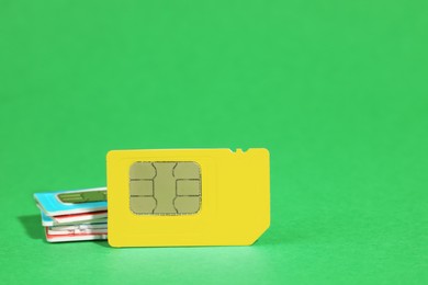 Photo of Different SIM cards on green background. Space for text