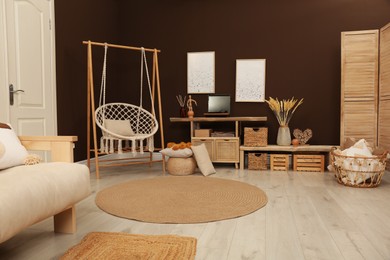 Photo of Trendy boho style furniture and decor in living room. Interior design
