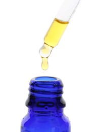 Photo of Dripping tincture from pipette into bottle isolated on white