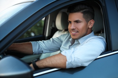 Handsome man in his modern car, view from outside