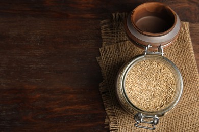 Photo of Jar with white quinoa on wooden table, top view. Space for text