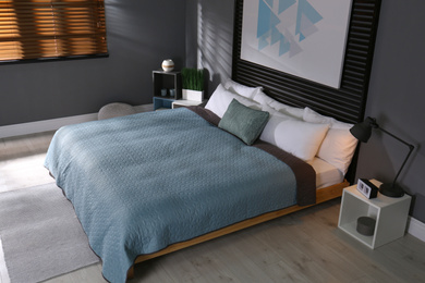 Photo of Comfortable bedroom with picture on decorative wall. Interior design